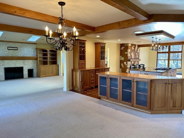 N7859 Lakeside Park Rd, Elkhart Lake, WI 53020 - kitchen featuring an inviting chandelier, beam ceiling, a fireplace, carpet floors, and decorative light fixtures