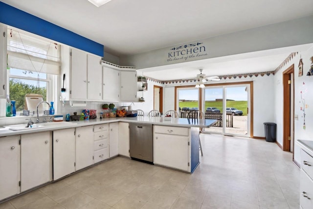 kitchen featuring dishwasher, backsplash, sink, a healthy amount of sunlight, and white cabinetry