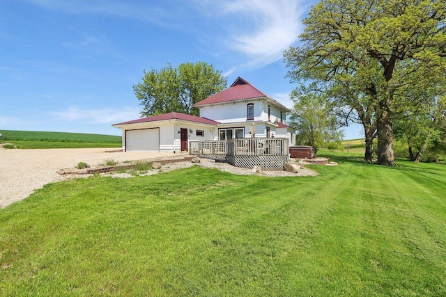 view of front of home with a garage, a deck, and a front yard