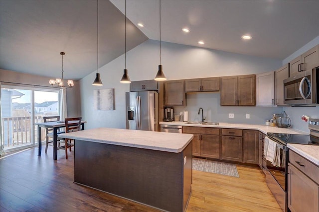 kitchen featuring light hardwood / wood-style flooring, stainless steel appliances, decorative light fixtures, and a notable chandelier