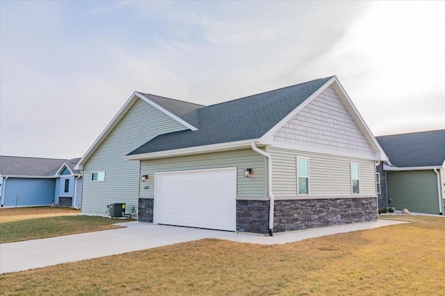 view of front of property featuring a front yard, a garage, and central air condition unit