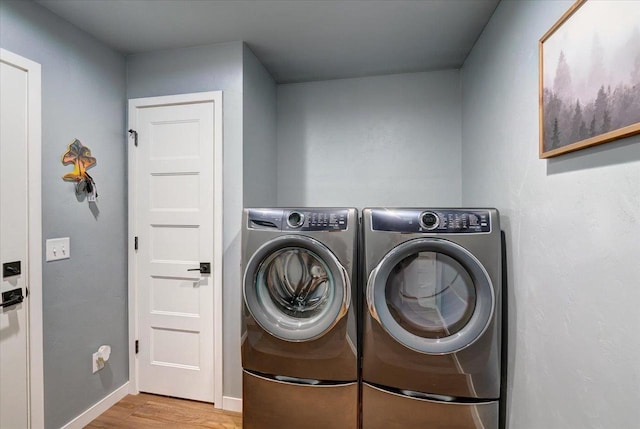 laundry room featuring light hardwood / wood-style floors and washing machine and dryer