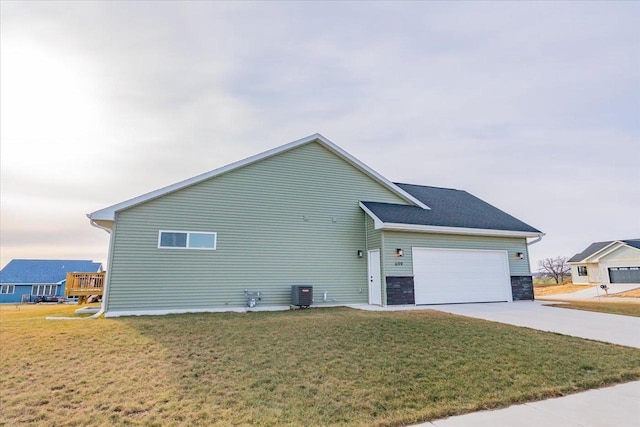 view of home's exterior with a garage, a yard, and central air condition unit