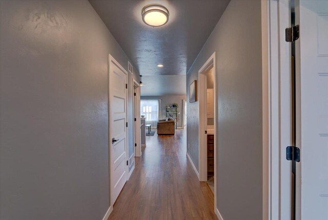 corridor with hardwood / wood-style flooring