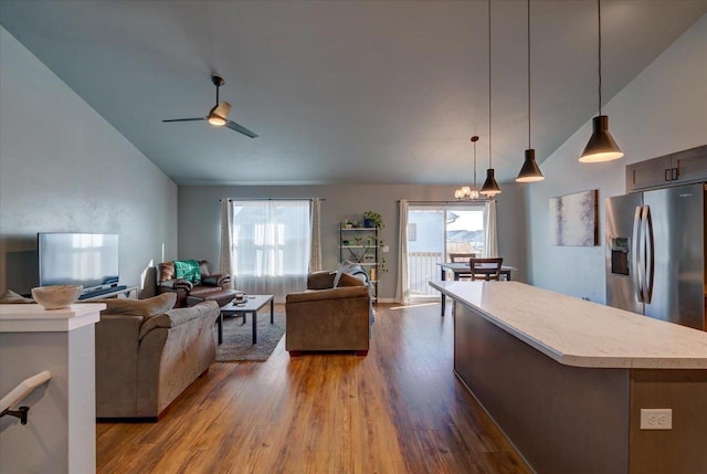 interior space with lofted ceiling, hardwood / wood-style floors, and ceiling fan with notable chandelier