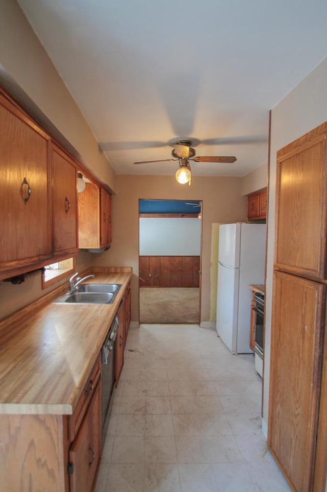 kitchen with white refrigerator, sink, stainless steel dishwasher, ceiling fan, and range