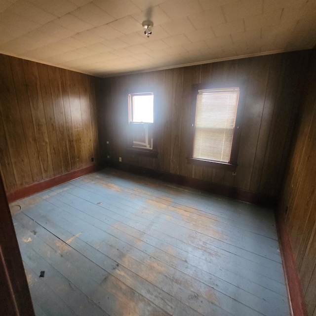 spare room featuring light wood-type flooring and wooden walls