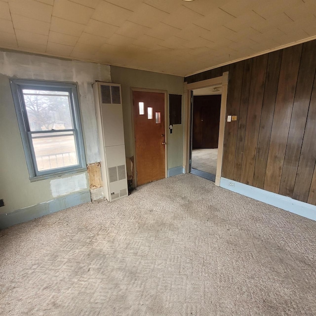 spare room with wood walls and light carpet