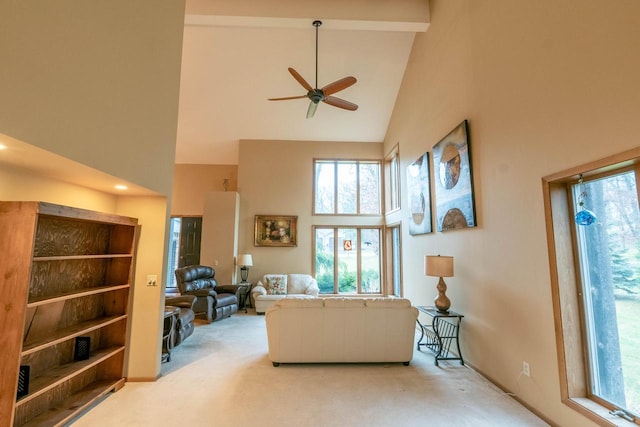 carpeted living room featuring beam ceiling, high vaulted ceiling, and ceiling fan