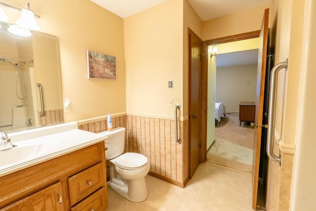 bathroom featuring vanity, toilet, a shower, and wooden walls