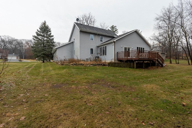 rear view of property featuring a lawn and a deck