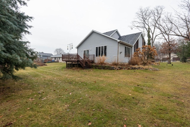 back of house featuring a lawn and a wooden deck