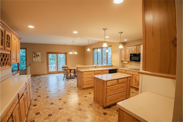 kitchen featuring a center island, sink, an inviting chandelier, kitchen peninsula, and black appliances