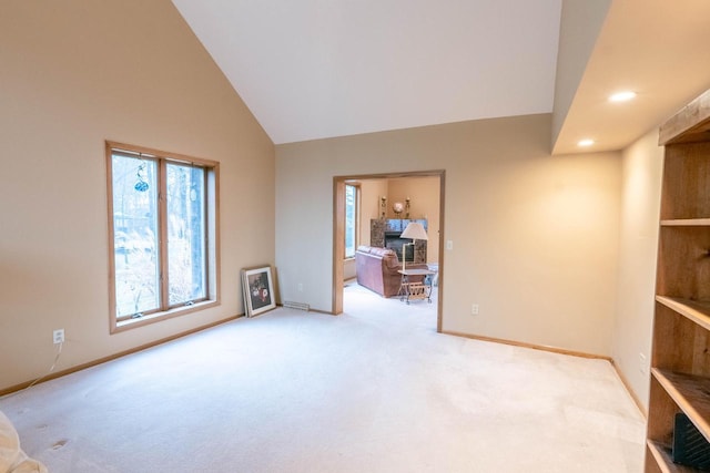 unfurnished living room featuring light carpet and high vaulted ceiling