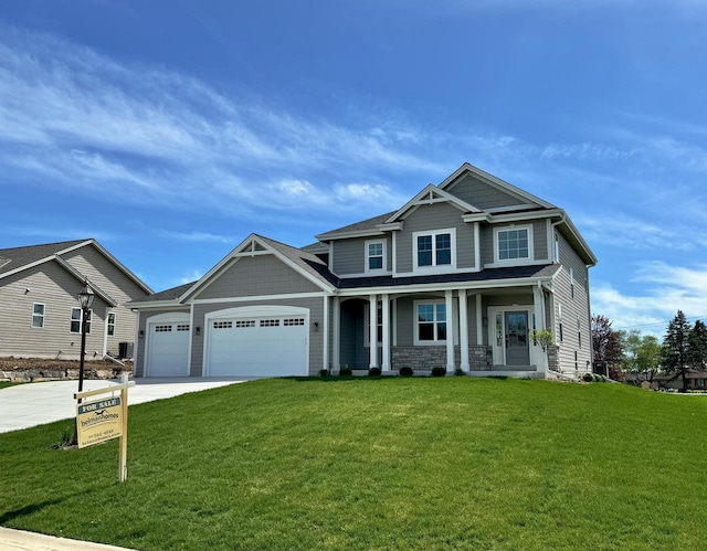 craftsman-style home featuring a garage, covered porch, and a front lawn