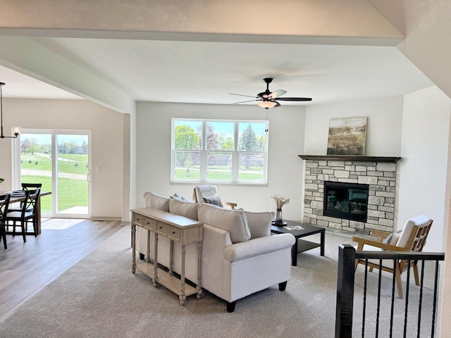 living room with ceiling fan, a fireplace, and light hardwood / wood-style flooring