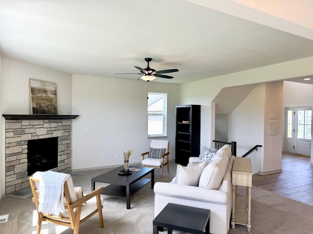 living room with ceiling fan, a fireplace, and carpet