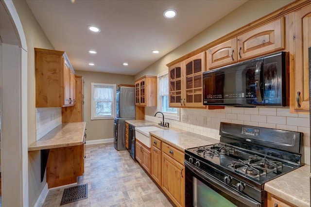 kitchen featuring sink, decorative backsplash, and black appliances