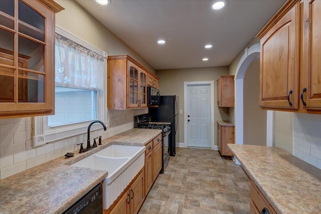 kitchen featuring sink, backsplash, and black appliances