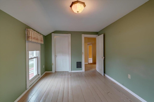 unfurnished bedroom featuring light hardwood / wood-style floors and vaulted ceiling