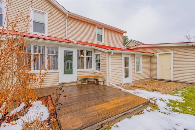 snow covered rear of property featuring a wooden deck