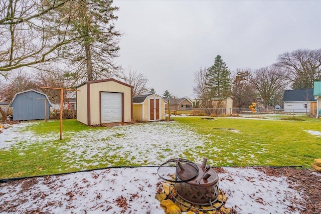 yard covered in snow with an outdoor fire pit and a storage unit