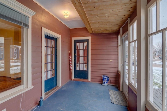 unfurnished sunroom with a healthy amount of sunlight and wood ceiling