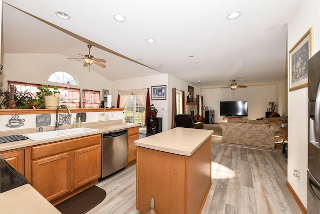 kitchen featuring stainless steel dishwasher, sink, light hardwood / wood-style flooring, a kitchen island, and lofted ceiling