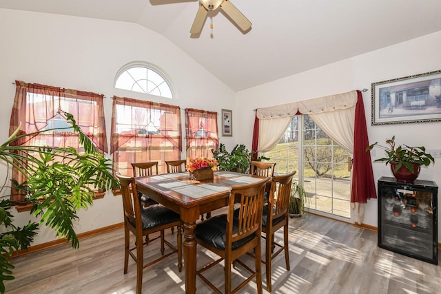 dining space with ceiling fan, vaulted ceiling, and hardwood / wood-style flooring