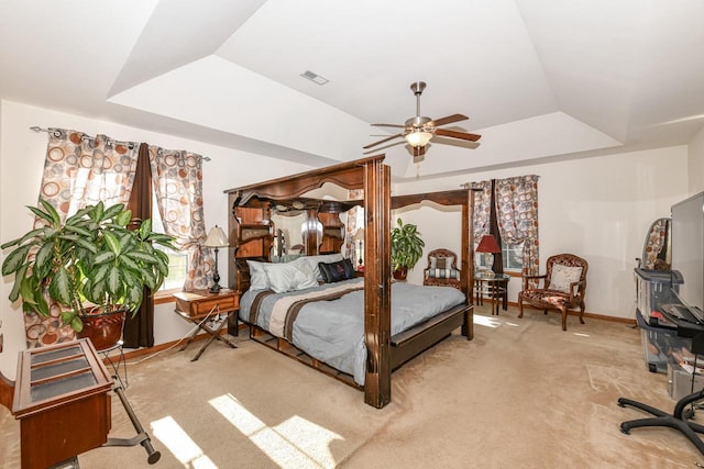 bedroom featuring a tray ceiling, ceiling fan, light carpet, and lofted ceiling