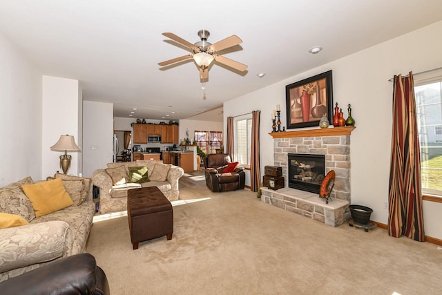 living room with ceiling fan, a fireplace, and light carpet