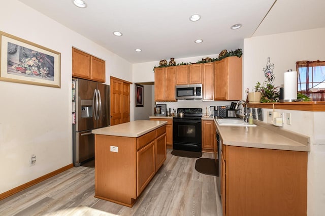 kitchen with light hardwood / wood-style floors, sink, stainless steel appliances, and a kitchen island