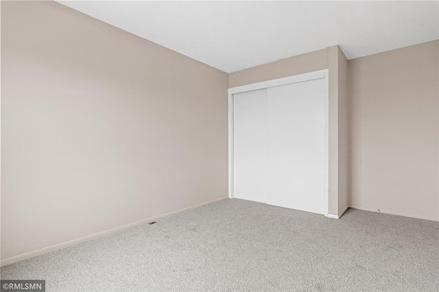 unfurnished bedroom featuring carpet and a closet