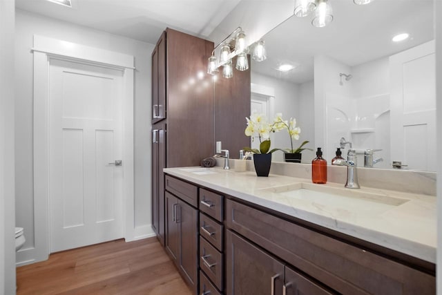 bathroom featuring walk in shower, toilet, vanity, and hardwood / wood-style flooring