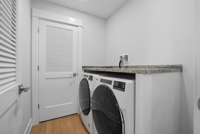 clothes washing area featuring light hardwood / wood-style flooring and independent washer and dryer