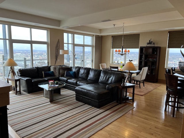 living room featuring light wood-type flooring and a notable chandelier