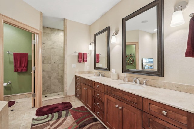 bathroom featuring tile patterned flooring, vanity, and tiled shower