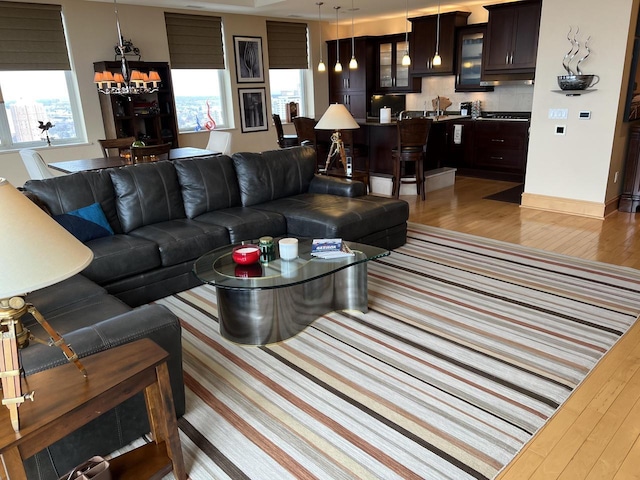 living room featuring a chandelier and light hardwood / wood-style flooring