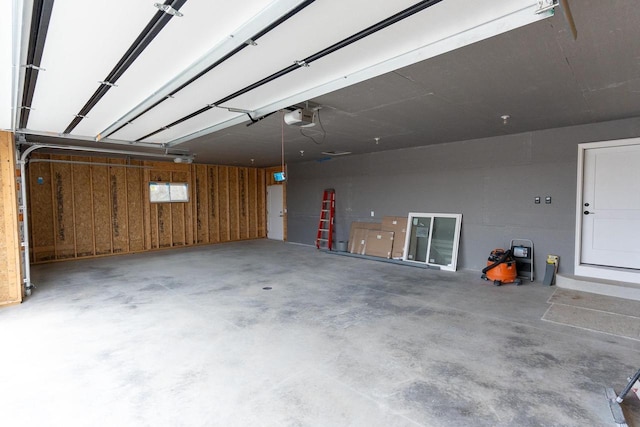 garage featuring a garage door opener and wood walls