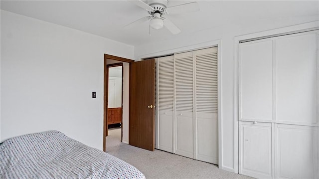 bedroom featuring light carpet, ceiling fan, and multiple closets