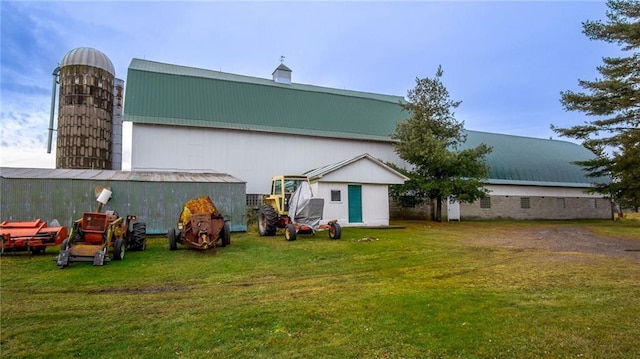 rear view of property with a yard and an outbuilding