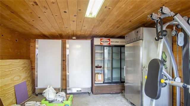 miscellaneous room featuring wood ceiling, concrete flooring, and wooden walls