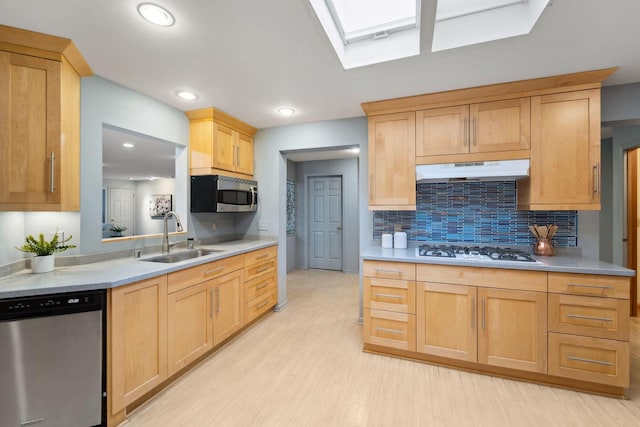 kitchen with decorative backsplash, appliances with stainless steel finishes, sink, light brown cabinets, and light hardwood / wood-style floors