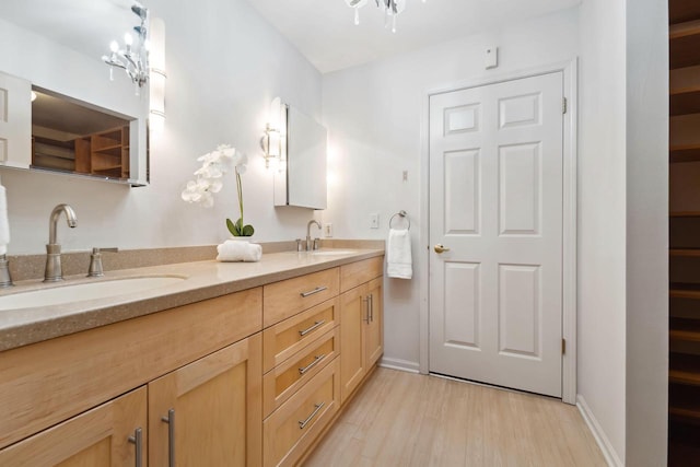 bathroom with vanity, a chandelier, and wood-type flooring