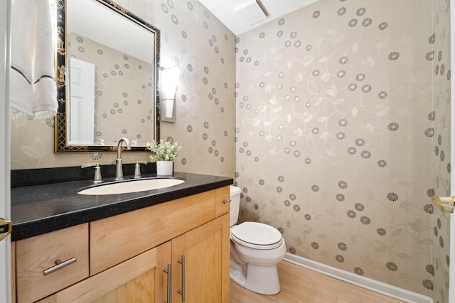 bathroom with hardwood / wood-style floors, vanity, and toilet