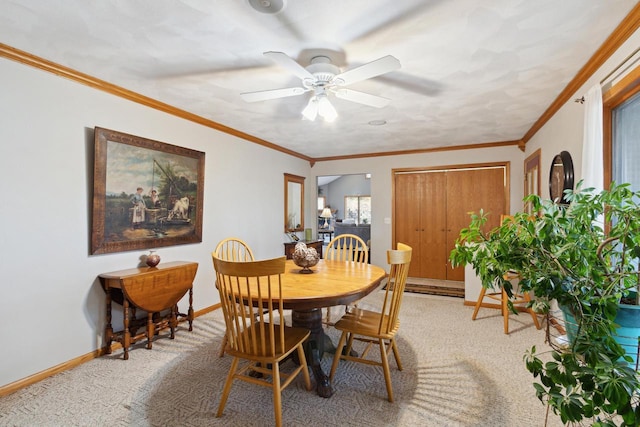 carpeted dining room featuring ceiling fan, baseboard heating, and crown molding