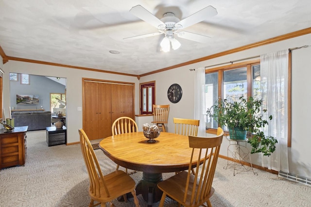 dining space with light carpet, ceiling fan, and ornamental molding