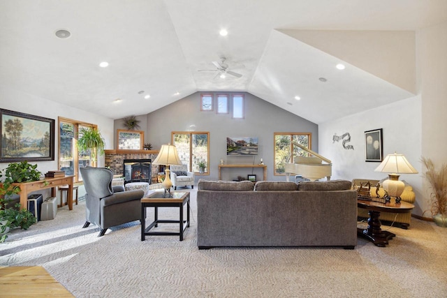 carpeted living room featuring ceiling fan and a stone fireplace