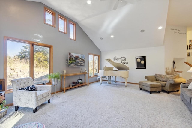 living room with ceiling fan, a healthy amount of sunlight, light colored carpet, and high vaulted ceiling