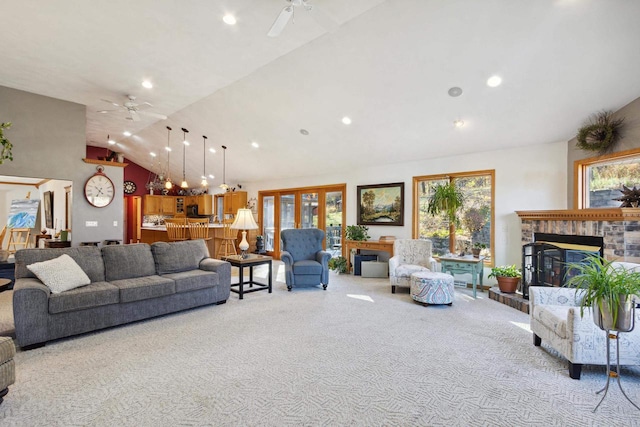 carpeted living room with ceiling fan, high vaulted ceiling, and a brick fireplace